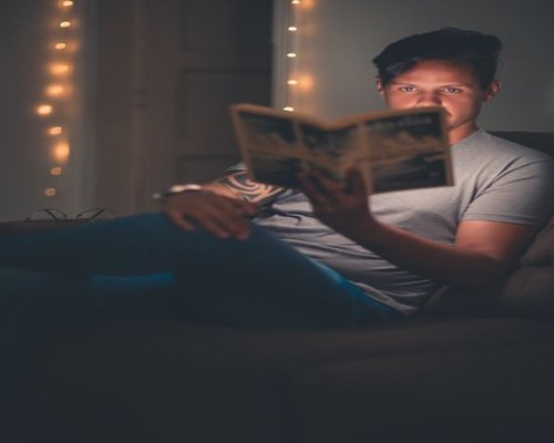 person reading a book in a comfortable room on a calm evening